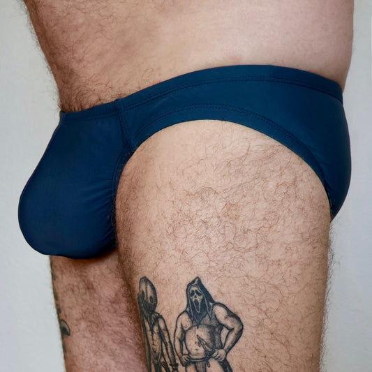 Person wearing blue underwear with tattoos on legs
